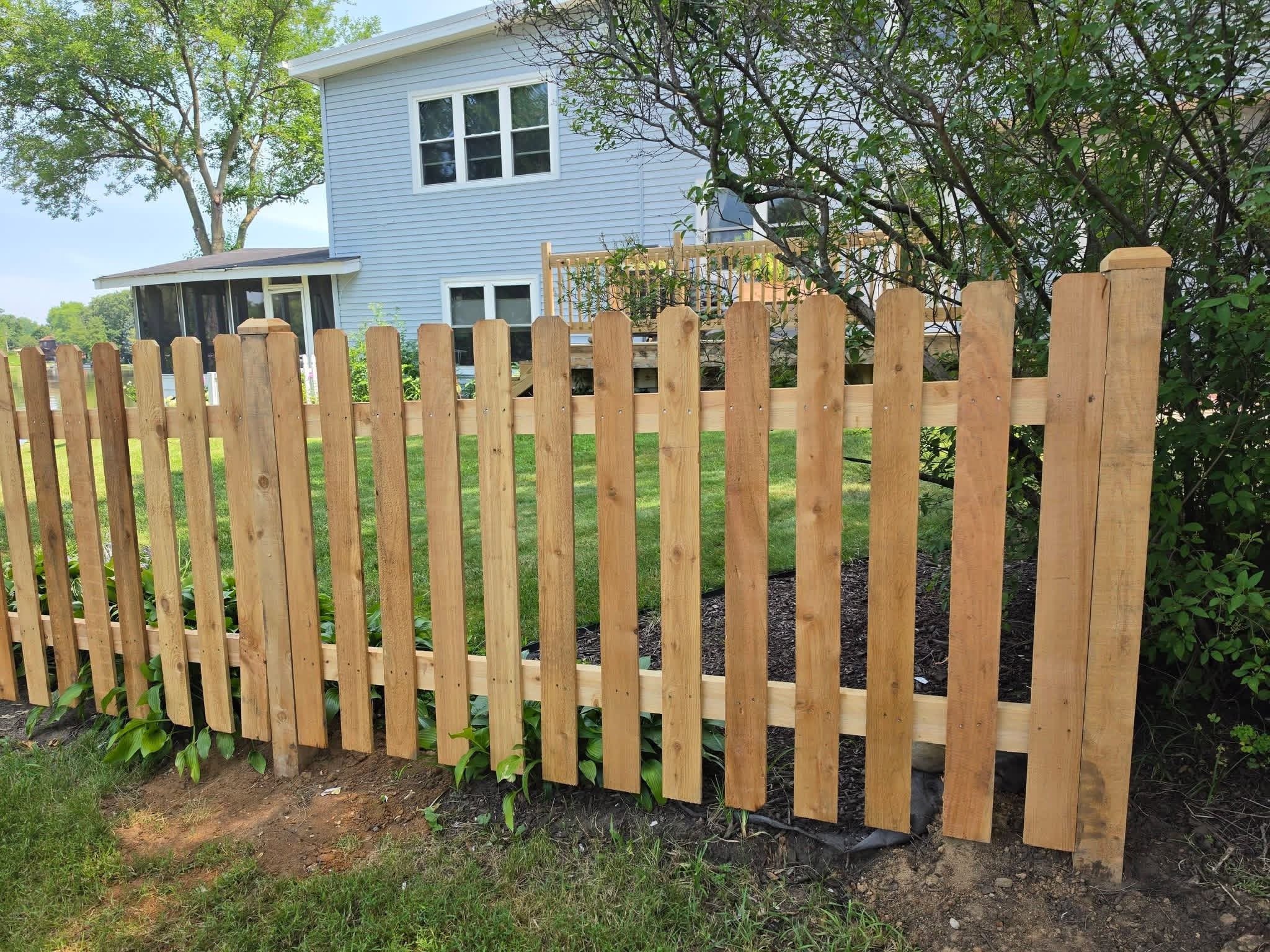 Open wood picket fence across a residential lawn.